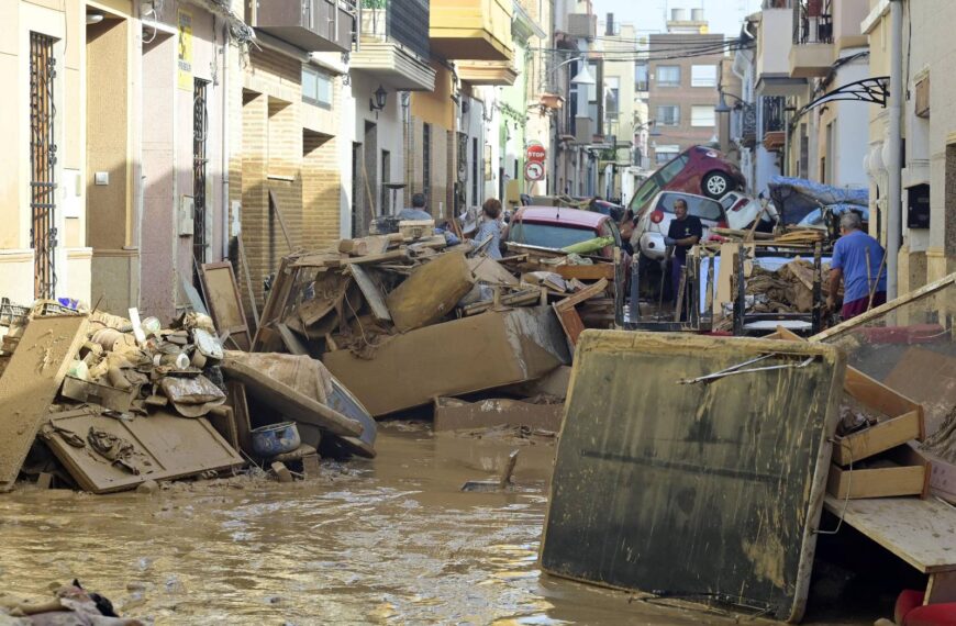 Residents d'Alfafar intenten rentar les seves cases mentre el carrer està ple de fang arran de la DANA.