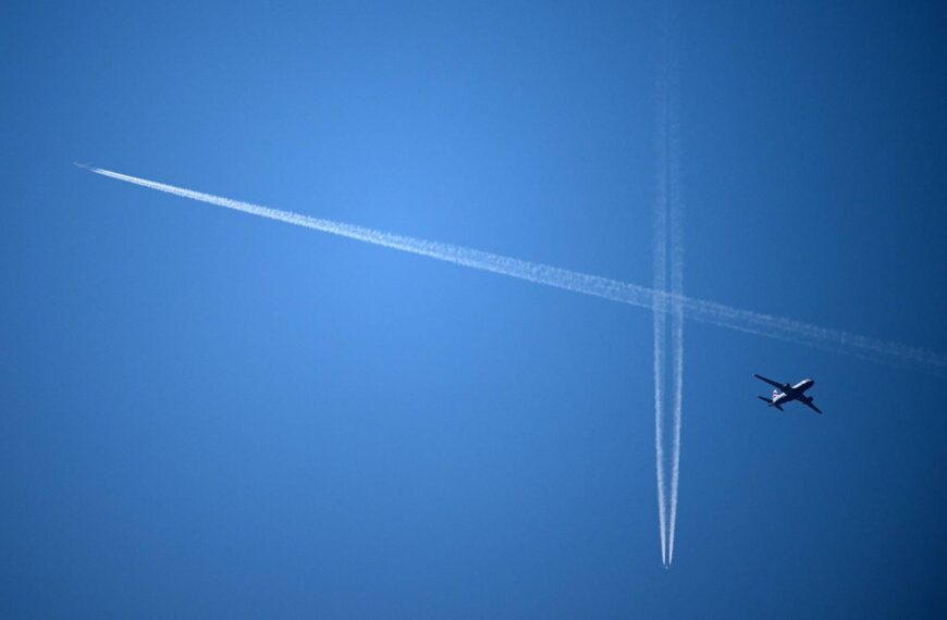 Un avió de passatgers de British Airways (dreta) vola sota altres avions i les esteles de condensació creades per aquests al cel de Londres el 15 de setembre de 2023.