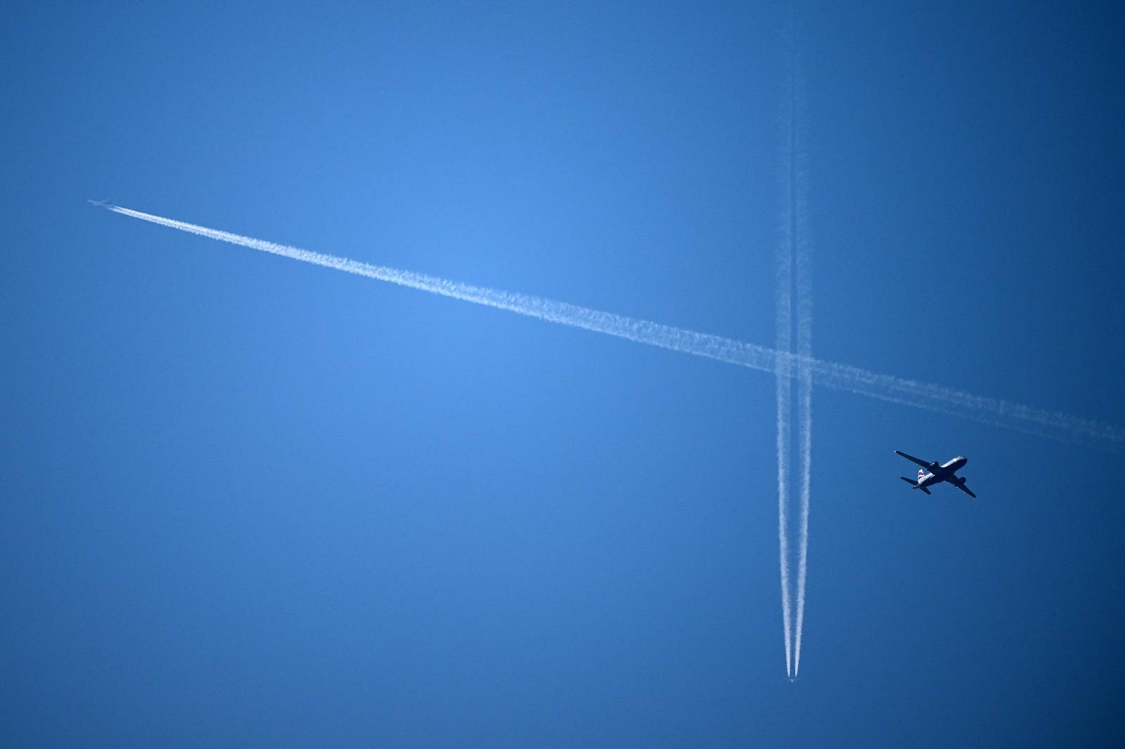 Un avió de passatgers de British Airways (dreta) vola sota altres avions i les esteles de condensació creades per aquests al cel de Londres el 15 de setembre de 2023.