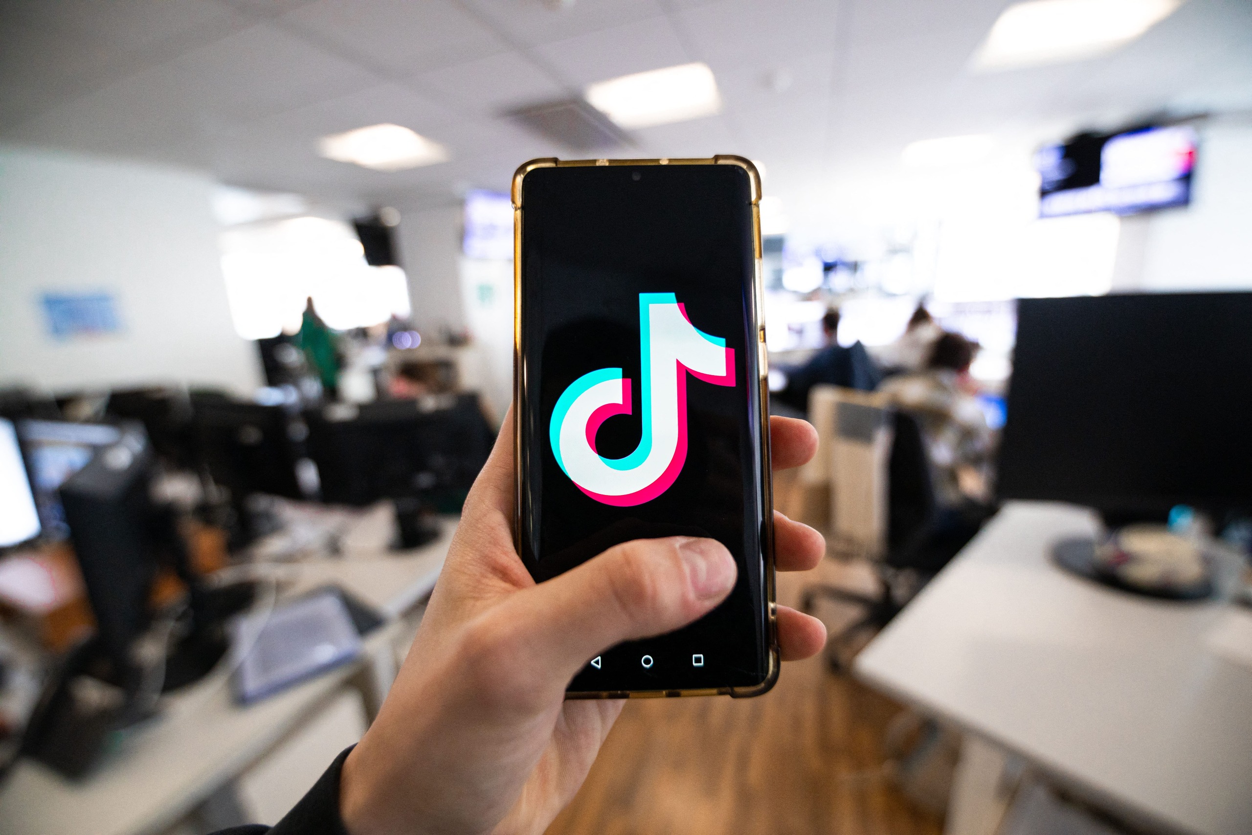 Un home mostra un mòbil amb l'aplicació de TikTok en una redacció periodística. (Antonin UTZ / AFP)