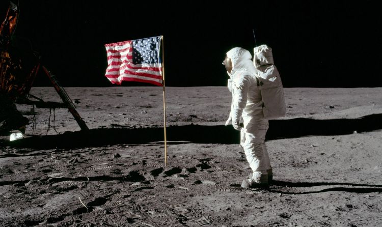 Un astronauta trepitjant la lluna al costat de la bandera dels Estats Units